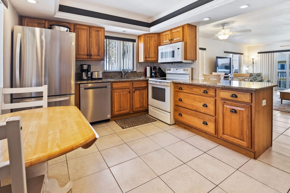 Cook up seaside favorites in this spacious kitchen featuring modern appliances, ample counter space, and a cozy dining nook—perfect for enjoying meals during your beach vacation.