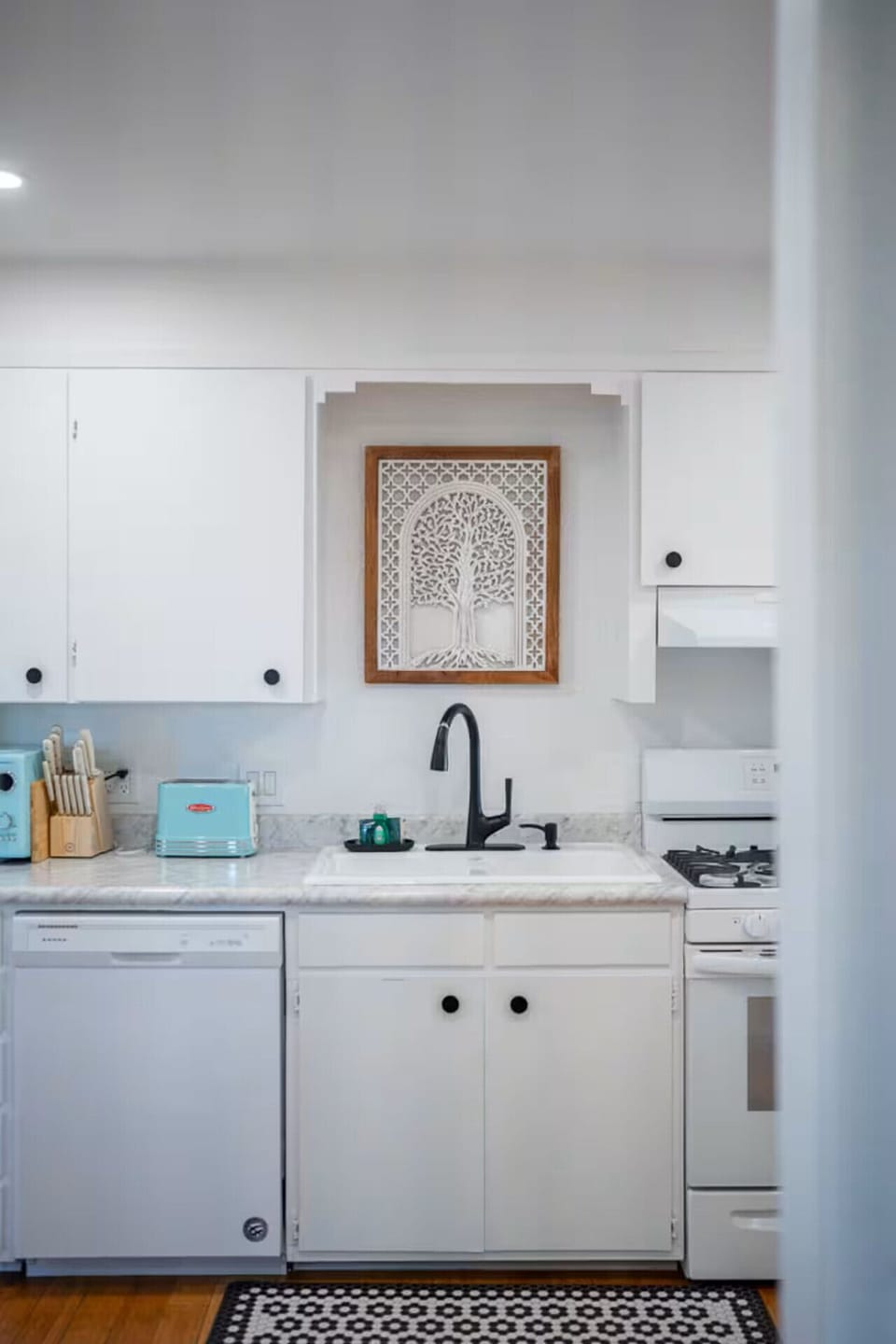 A clean and inviting kitchen with a farmhouse sink, retro-style appliances, and plenty of prep space—ideal for creating delicious meals or enjoying a cozy cooking experience.