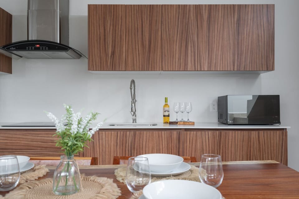 Modern kitchen with wood cabinets, sleek design, and all essentials ready.