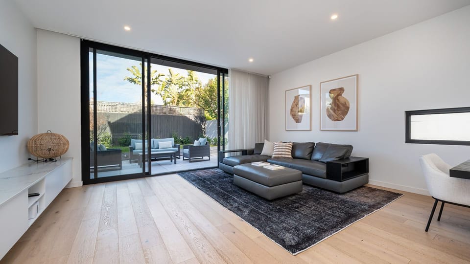 Rear light and bright living space with smart tv, large sliding windows into courtyard