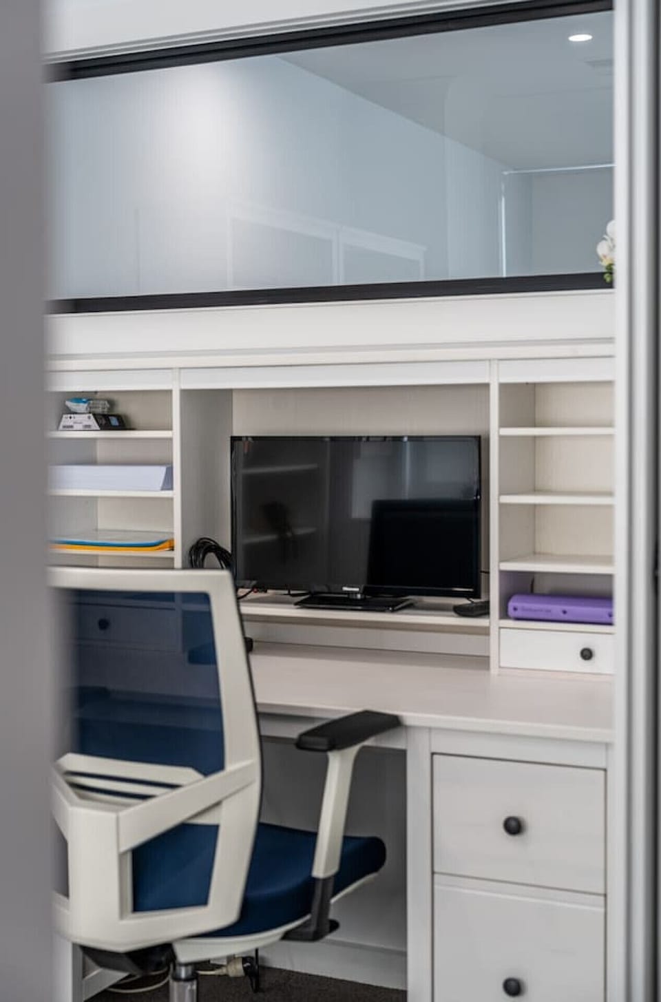 The monitor and ergonomic chair support a comfortable workspace for remote work.