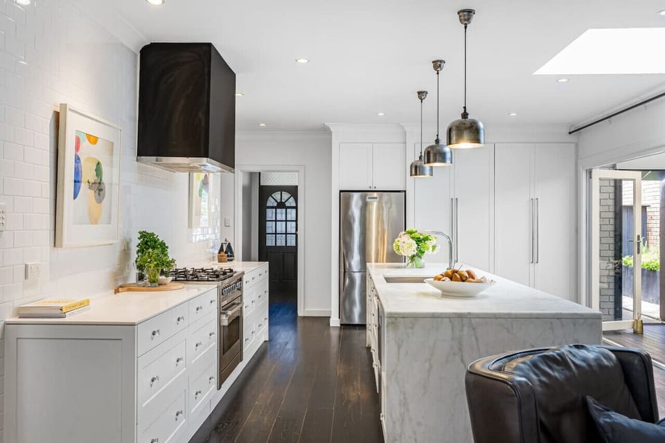 Prepare meals in the bright kitchen with a gas cooktop, marble benchtop, and breakfast bar seating.