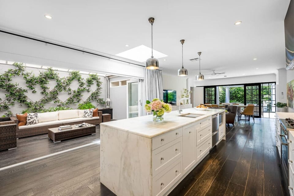 Gather around the marble island as skylights pour in natural light, flowing seamlessly into the alfresco lounge for relaxed indoor-outdoor living.