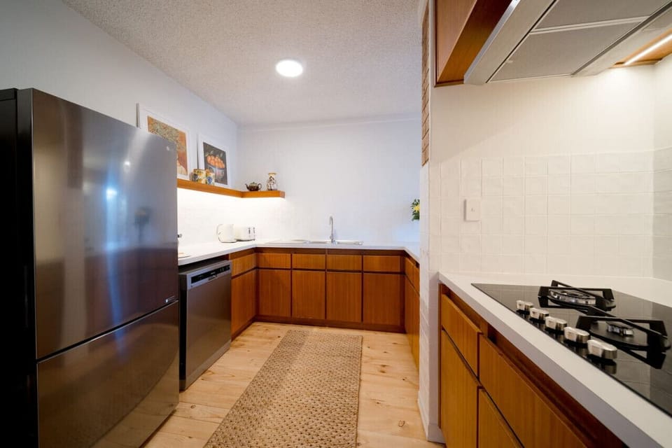 Whip up meals with ease in the sleek, fully equipped kitchen featuring a gas cooktop, coffee machine, and ample bench space.