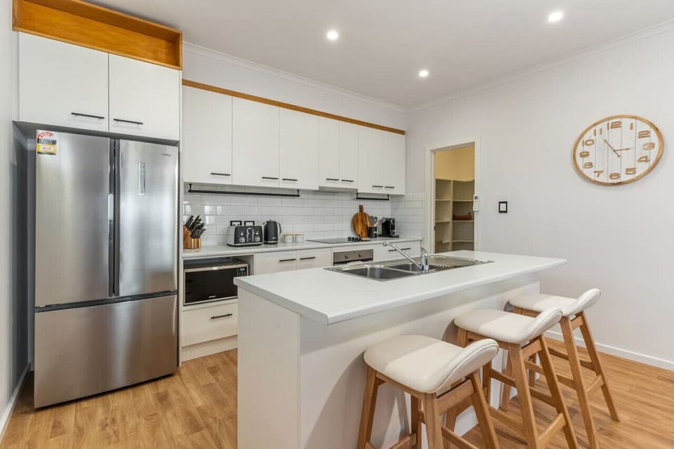 This stylish kitchen features a large island with comfortable bar seating and warm ambient lighting.