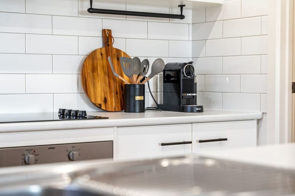 White subway tiles, wooden accents, and a high-quality coffee machine ready for your morning brew.