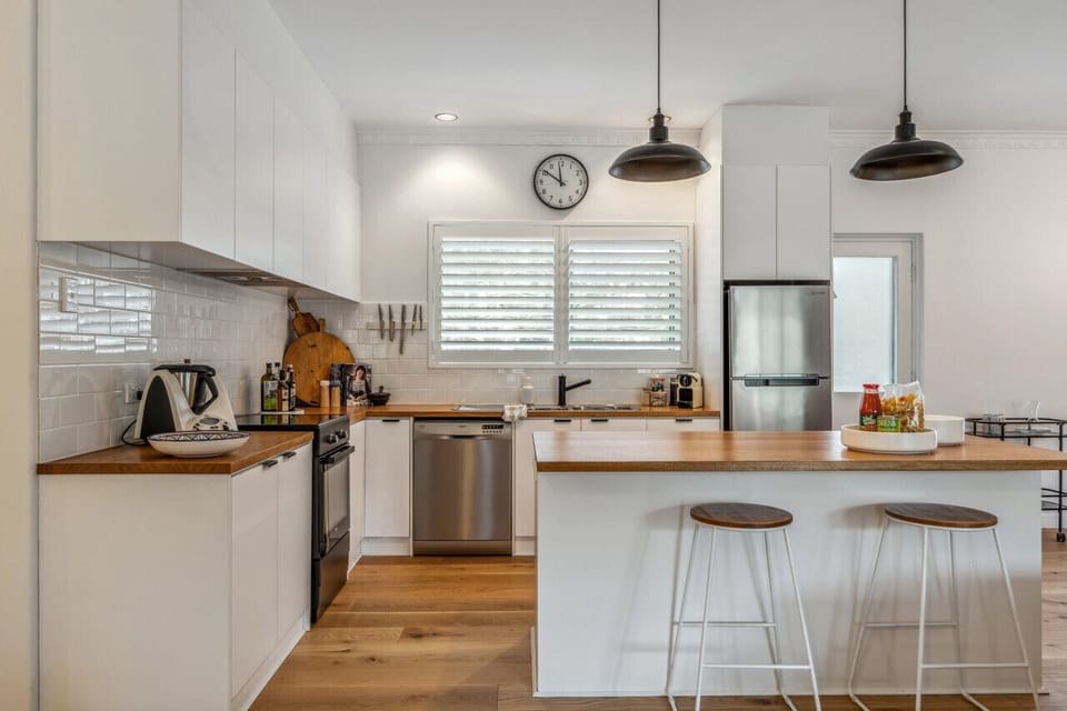 Clean lines, timber benchtops, and modern appliances give the kitchen a bright contemporary feel, fully equipped for everything from casual breakfasts to shared family dinners.