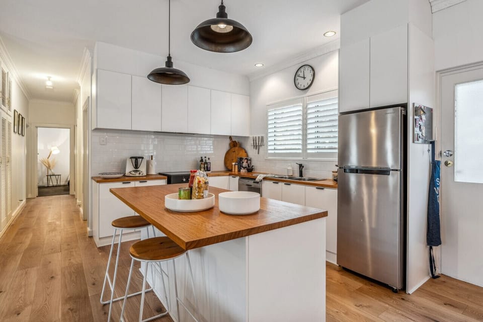 Gather around the generous kitchen island with bar seating, where morning coffees, casual breakfasts, and shared cooking moments become part of the experience.
