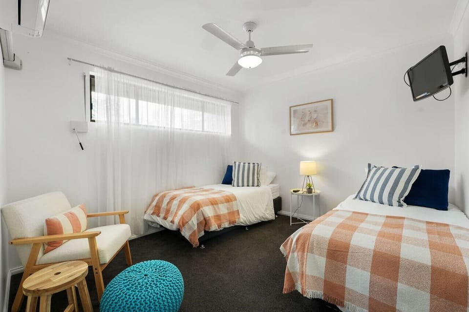 Wind down in the second bedroom, offering two single beds that can be arranged together if needed, along with cooling and a quiet space to recharge.