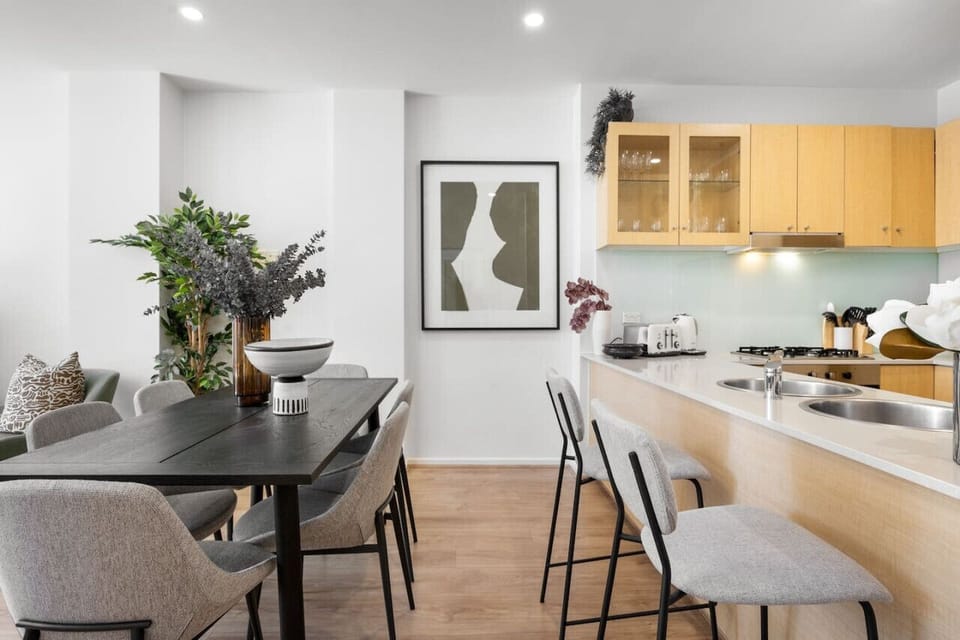 Gather around the elegant six-seater dining table for shared meals or game nights beneath soft lighting and curated artwork, just steps from the kitchen.