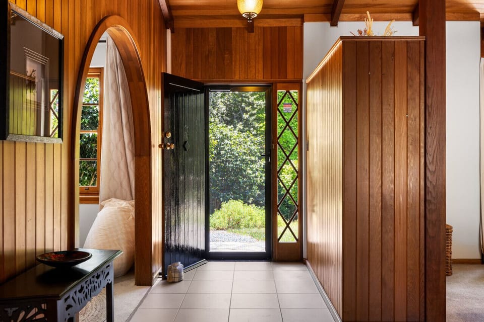 Arrive through a timber-clad entry that sets a warm, welcoming tone.