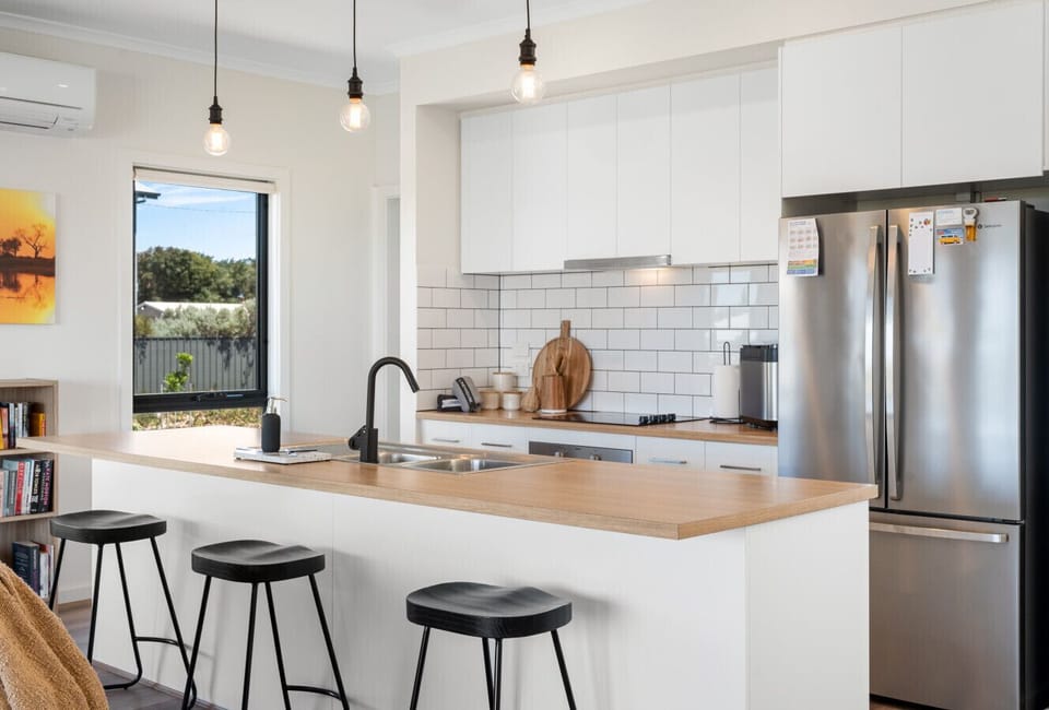 Start the morning at the kitchen island bench where three stools create the perfect perch for coffee, casual breakfasts or chatting with the cook.