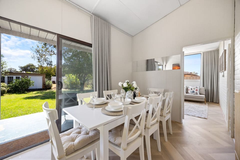 Enjoy meals together in the bright dining area for eight, with large sliding doors that open onto the garden for effortless indoor-outdoor flow.