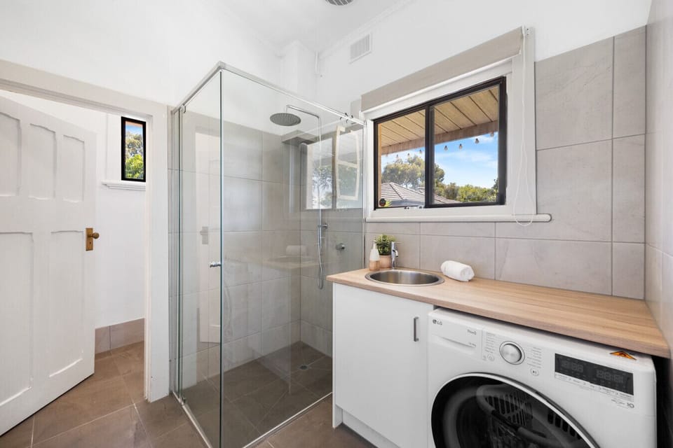The second bathroom combines convenience with a rainfall shower, laundry sink, and a washer for your laundry routine.