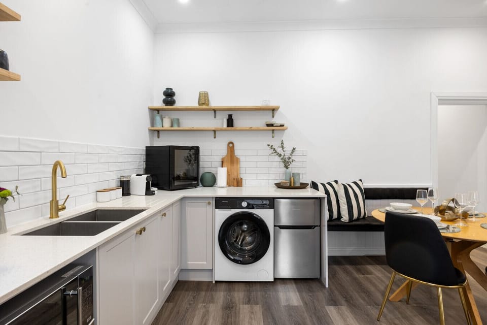Efficiency meets elegance – this sleek kitchen comes fully equipped and cleverly integrated with laundry essentials.