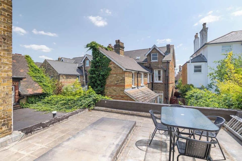 - Outdoor terrace with dining set and views of neighborhood rooftops  
- Perfect for al fresco meals and enjoying the fresh morning air  
- Airbnb home with private outdoor space for relaxing evenings  