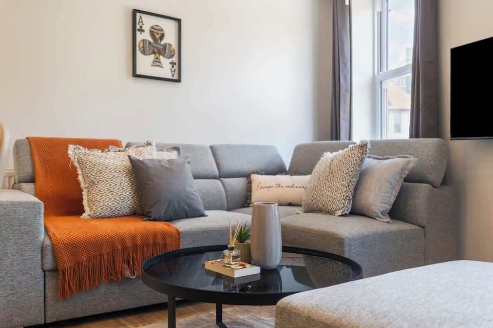 - Modern lounge with sectional sofa and chic cushions for cozy seating  
- Coffee table styled with accents adds a touch of comfort and charm  
- Perfect Airbnb living room for relaxing after a day of exploring 