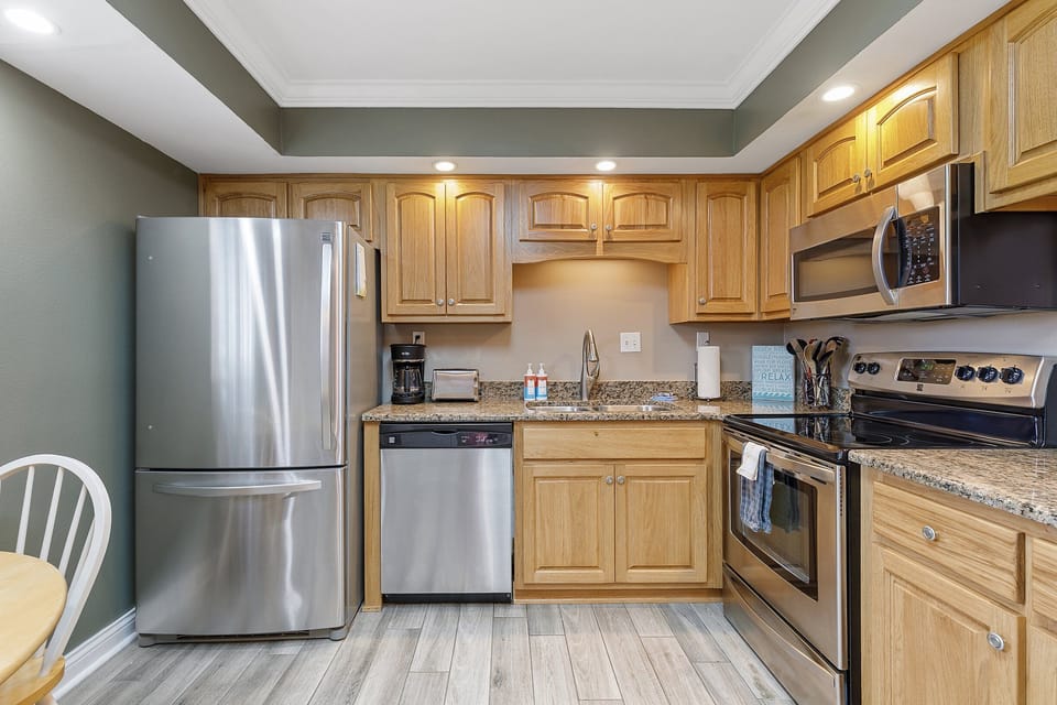 Cook up beach day favorites in this fully equipped kitchen featuring stainless appliances, granite counters, and warm coastal style—perfect for your beachfront stay.