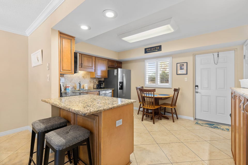 Enjoy a relaxed beach stay in this bright kitchen and dining area, perfect for quick bites before heading to the shore or winding down after a day of coastal fun.