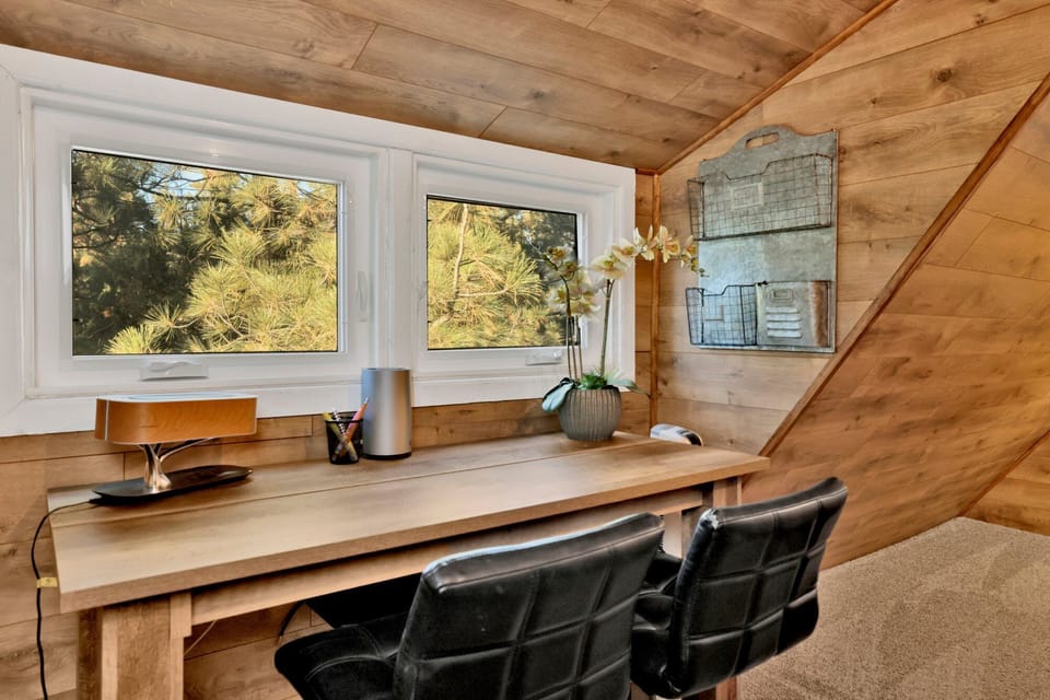 Spacious bedroom featuring work area, stylish furniture, and natural light.
