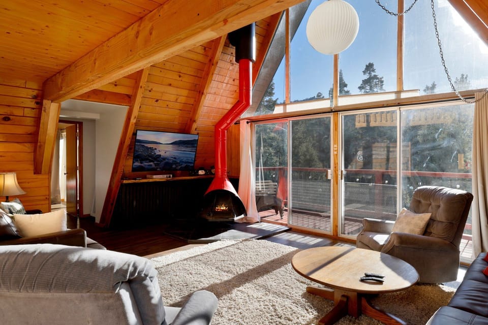 Relax in the cozy living room, where a wide picture window frames beautiful mountain views and fills the space with natural light perfect for slow mornings and peaceful evenings.