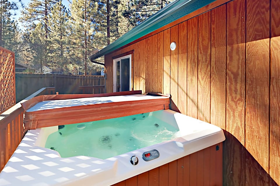 Private outdoor hot tub, surrounded by tall pines, perfect for relaxing under the trees after a day of adventure—enjoy peaceful forest views, fresh air, and a truly rejuvenating stay.
