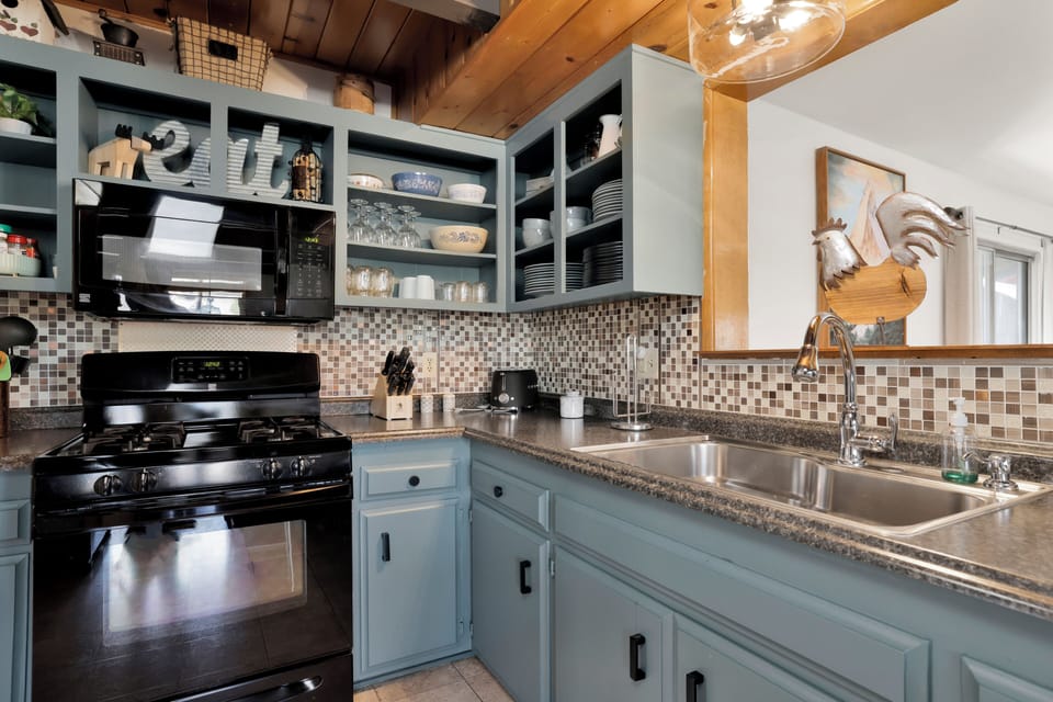 Fully equipped cabin kitchen with ample cabinetry, stove, fridge, and coffee maker—perfect for cooking meals, morning coffee, and feeling right at home on your stay.