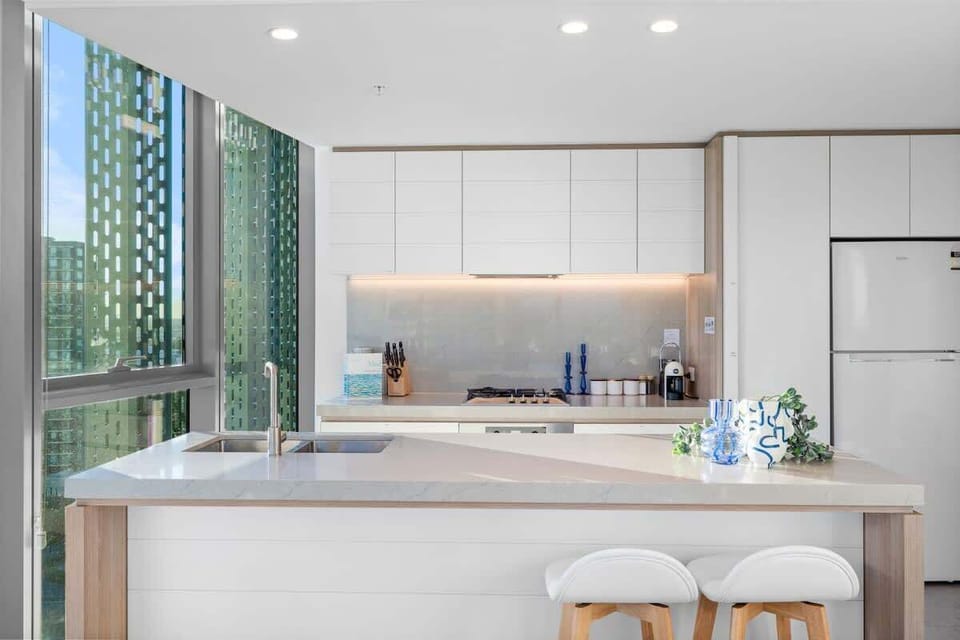Modern kitchen with stone benchtops, breakfast bar, and premium appliances.