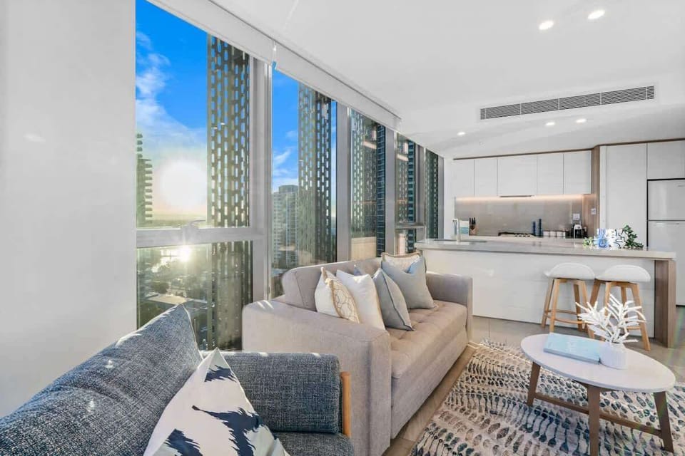 Sun-drenched living space with floor-to-ceiling windows and skyline views.