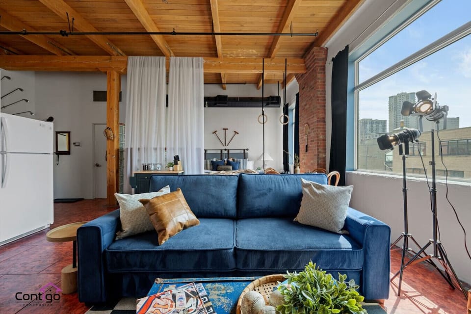 Open-concept studio loft with king bed, sofa bed, and stylish industrial design. Central A/C, full kitchen, and in-suite laundry, everything you need for a comfortable city stay.