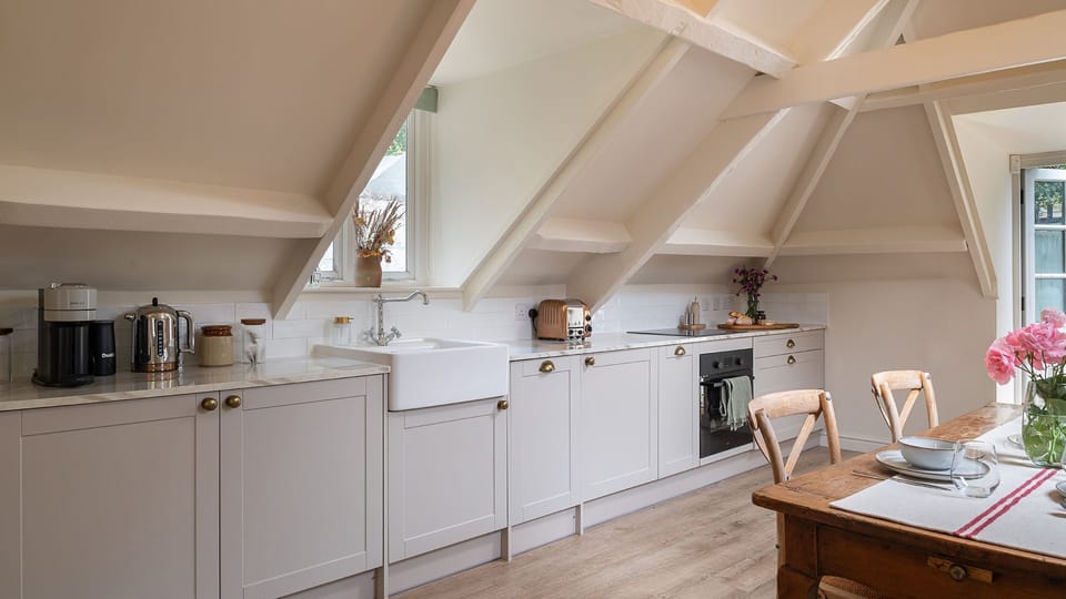 Set along one side of the open plan area, the kitchen has an oven and hob, dishwasher, fridge, Nespresso coffee machine, kettle and toaster.