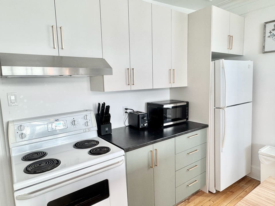 Cette cuisine moderne et fonctionnelle offre tout le nécessaire pour cuisiner confortablement, avec des électroménagers récents pensés pour votre quotidien.