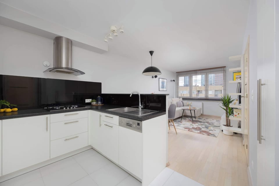 A spacious view of the kitchen and dining space featuring contemporary appliances, generous countertops, and light wood floors that create a warm and inviting atmosphere.