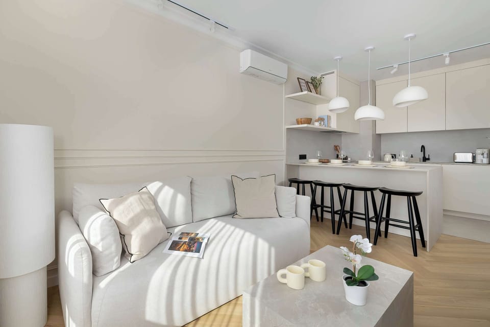 Air-conditioned living area with a fold-out sofa, TV, and a kitchenette with a dining area.