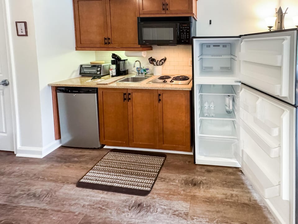Galley kitchen with all you need to prepare modest meals that has a near full fridge
