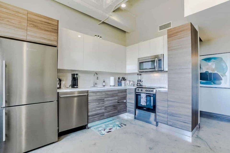 Cooking made easy with a blender, pots, hot water kettle, sleek stainless appliances, and modern design. All essentials are ready for your use.