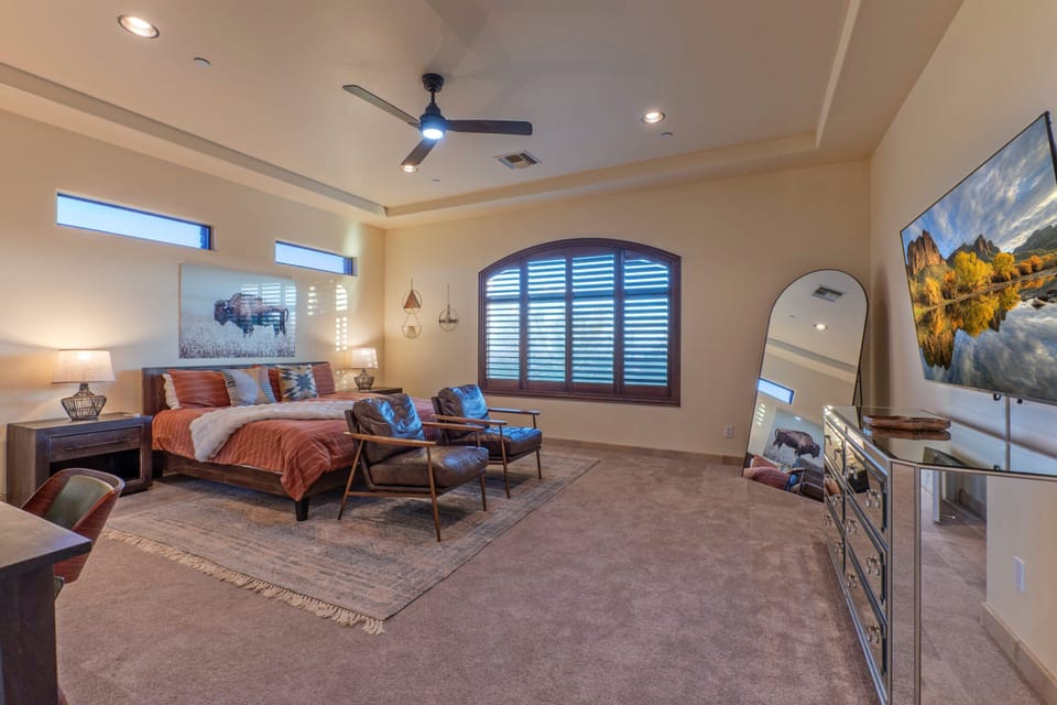 Spacious primary suite has a king bed, en suite bath, TV, desk for remote work and amazing views.