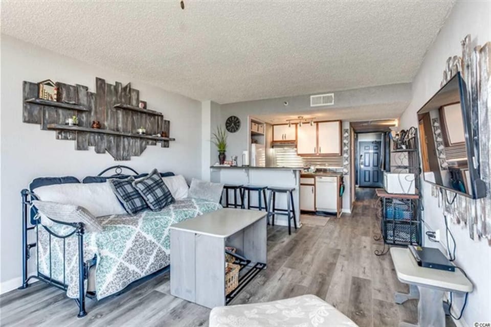 Cozy living area with large TV, coffee table, and comfortable seating