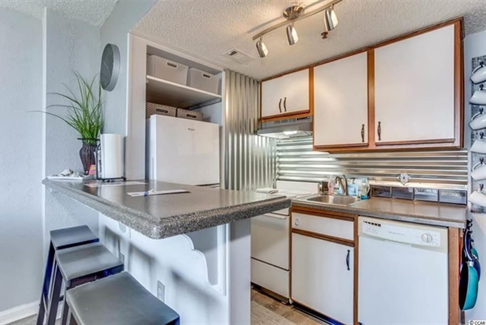 Full kitchen with stove, fridge, microwave, and wood cabinetry