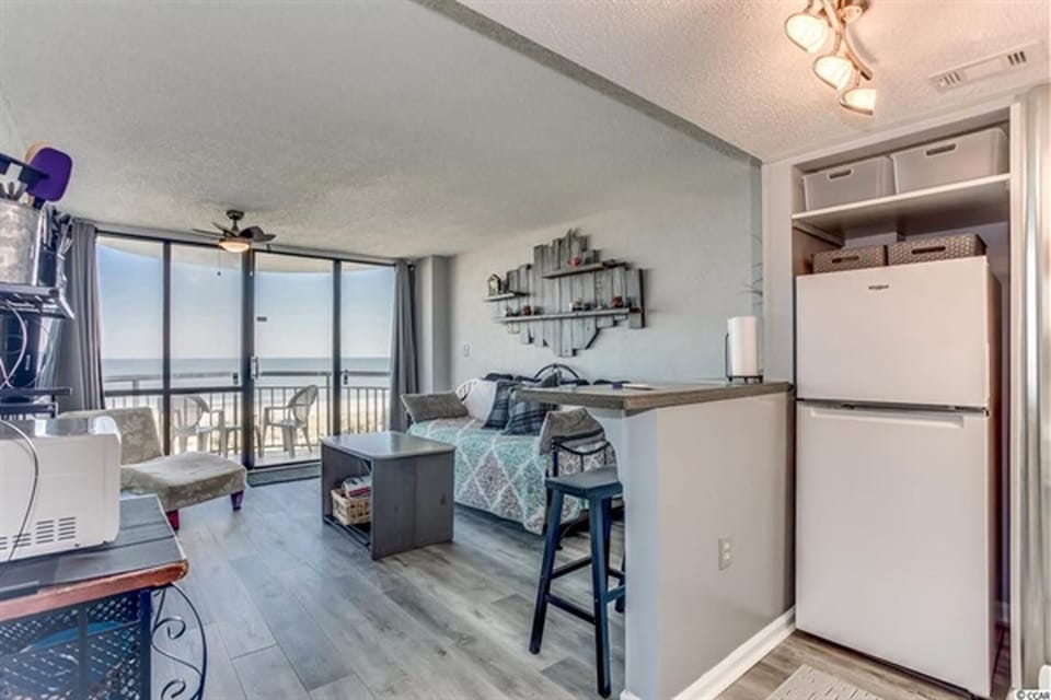 Living area with bar seating and ocean view through sliding doors