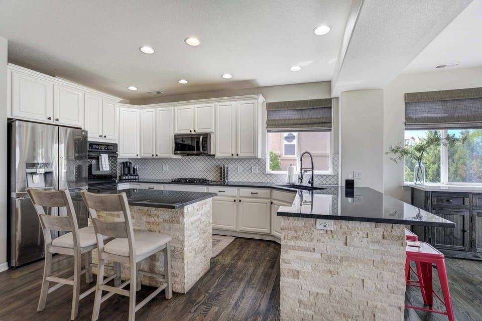 Cook, gather, and connect in this chef-ready space with dual prep islands, a gas cooktop, sleek tile backsplash, and plenty of natural light.

