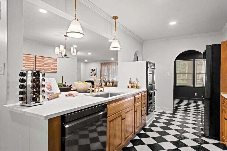 Expansive kitchen island with prep sink, dishwasher, and ample counter space. Ideal for group meals, entertaining, and easy flow between cooking and gathering areas.