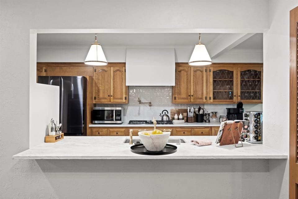 Bright kitchen pass-through with bar seating, ideal for casual meals, coffee, or entertaining. Designed for easy flow between the kitchen and main living spaces.