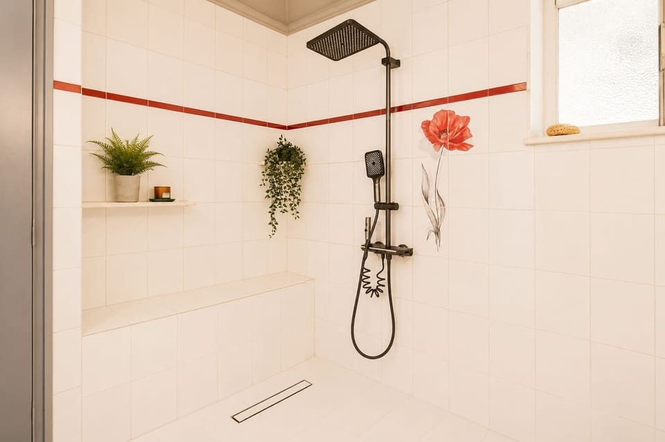 Modern shower with a rainfall showerhead and contemporary black fixtures