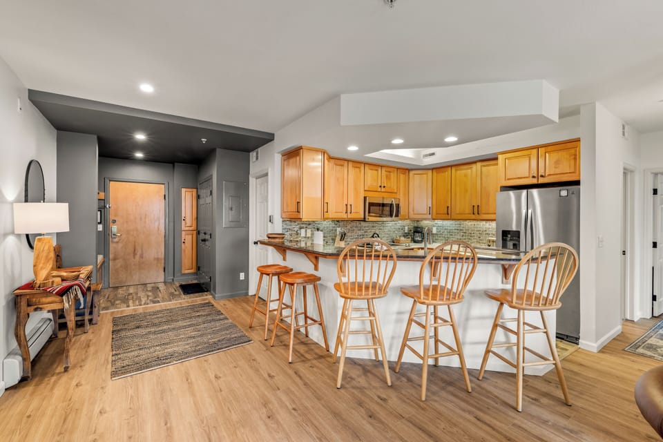 Your open-plan beautiful renovated kitchen welcomes you with warm wood cabinetry and stone counter tops, perfect for cooking and gathering around the breakfast bar.
