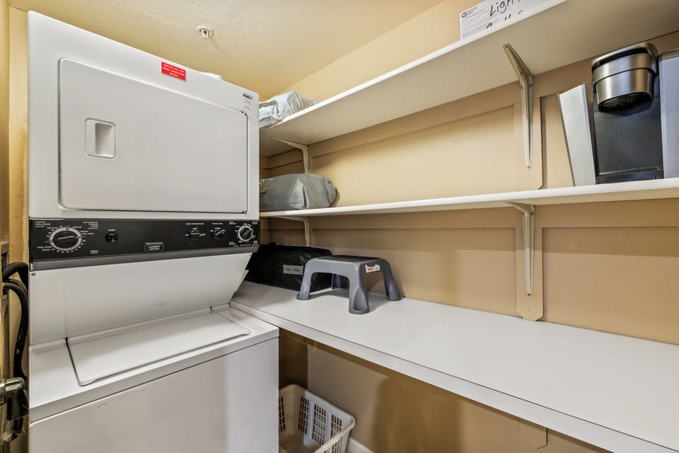 Your laundry stays fresh and convenient with this well-organized space featuring modern appliances and ample shelving for supplies.