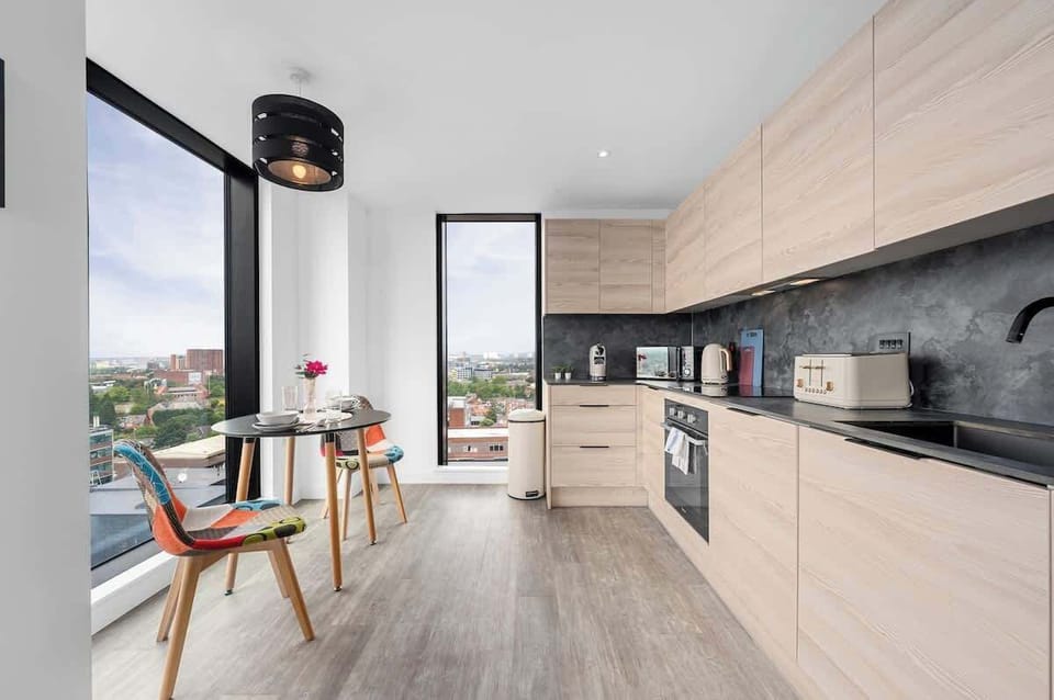Dining area next to floor-to-ceiling windows with views across the city, perfect for morning coffee
