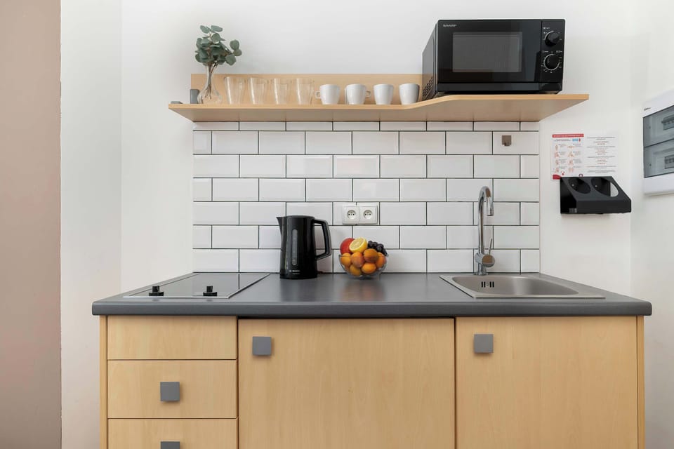  Modern kitchenette with light cabinets, induction hob, and a practical work surface.