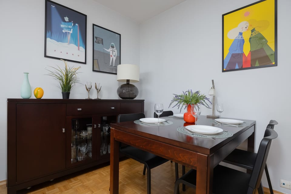 A different perspective of the living room emphasizing the dining area and wall art.