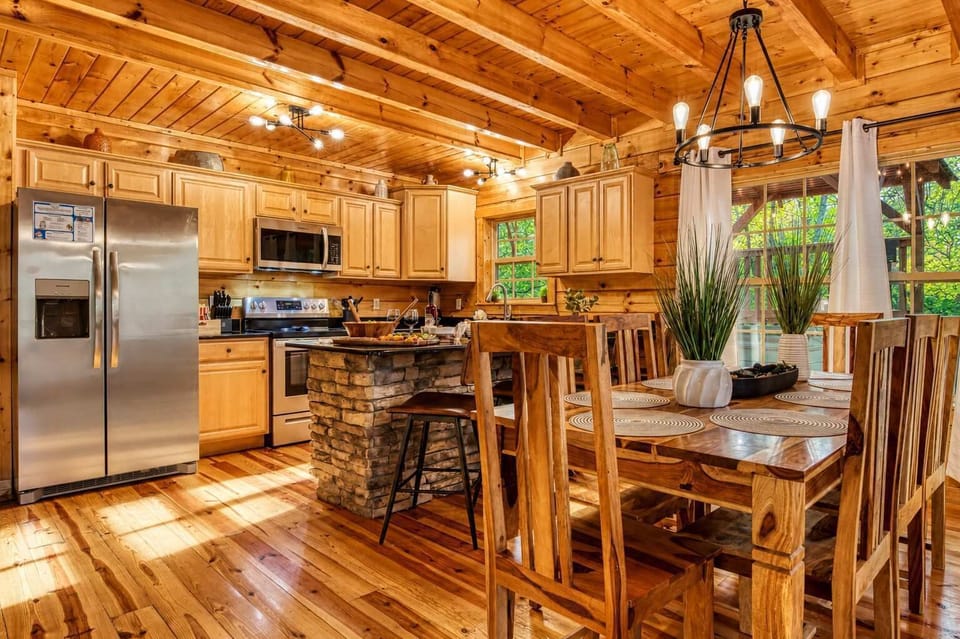 Cook and dine with ease in this gourmet kitchen, steps from the dining room, featuring stainless steel appliances and modern cabin style.
